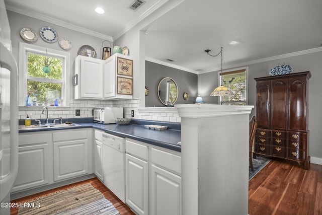 1009 9th St, Port Royal, SC 29935 - kitchen with white appliances, dark countertops, dark wood-style flooring, a peninsula, and white cabinetry