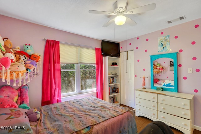 bedroom featuring visible vents, ceiling fan, and wood finished floors