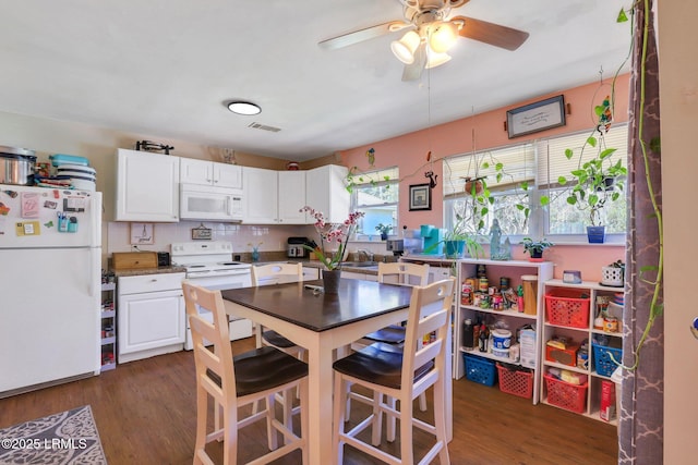 kitchen with visible vents, white appliances, white cabinetry, and dark wood-type flooring
