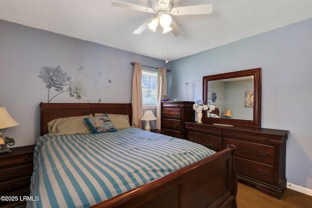 bedroom with baseboards, ceiling fan, and wood finished floors