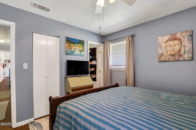 bedroom with visible vents, a textured ceiling, a closet, and a ceiling fan