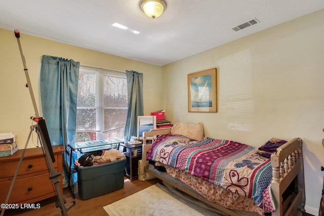 bedroom with visible vents and wood finished floors