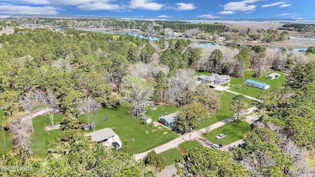 birds eye view of property with a wooded view and a water view