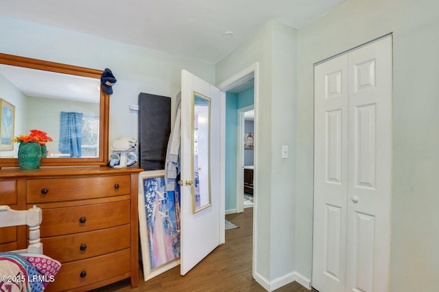 bedroom with a closet, baseboards, and wood finished floors