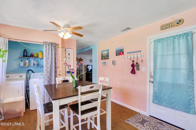 dining area featuring wood finished floors, baseboards, a ceiling fan, visible vents, and washing machine and clothes dryer