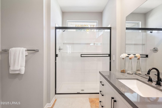 bathroom with vanity and a shower with door