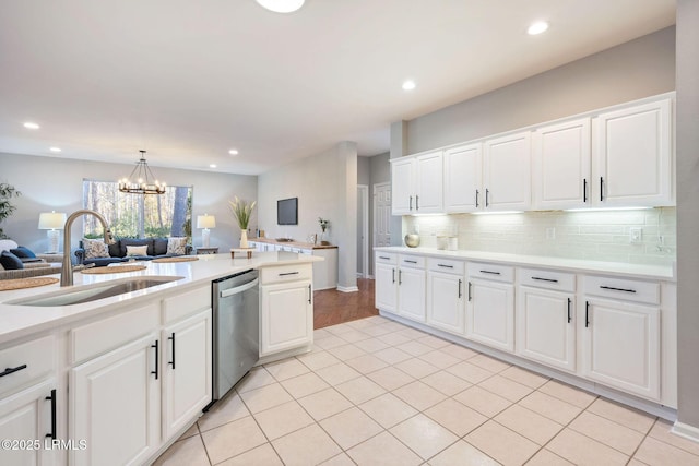 kitchen featuring pendant lighting, sink, dishwasher, tasteful backsplash, and white cabinets