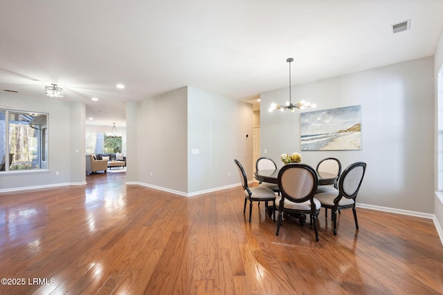 dining room with wood-type flooring and a notable chandelier