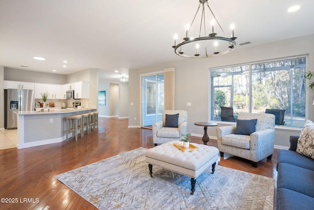 living room with a notable chandelier and light hardwood / wood-style floors