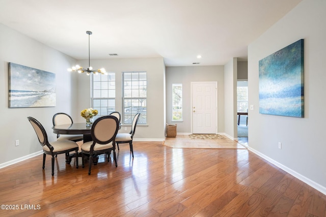 dining space featuring a notable chandelier and light wood-type flooring