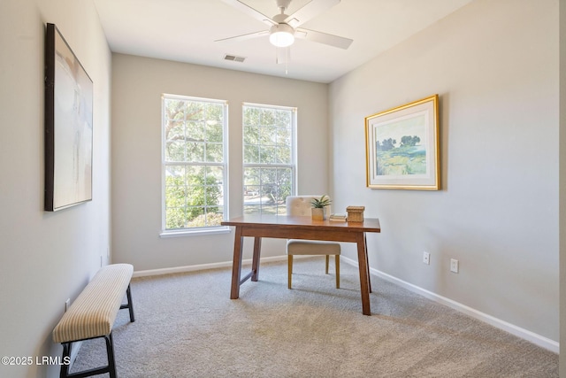 carpeted office space with ceiling fan