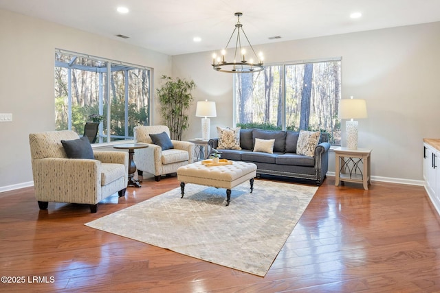 living room with hardwood / wood-style floors and an inviting chandelier