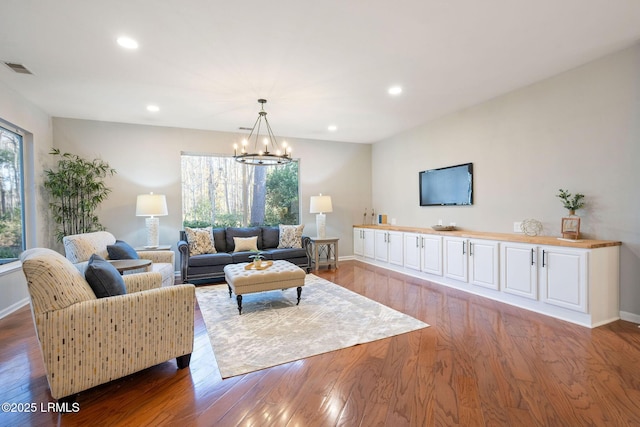 living room with an inviting chandelier and light hardwood / wood-style floors