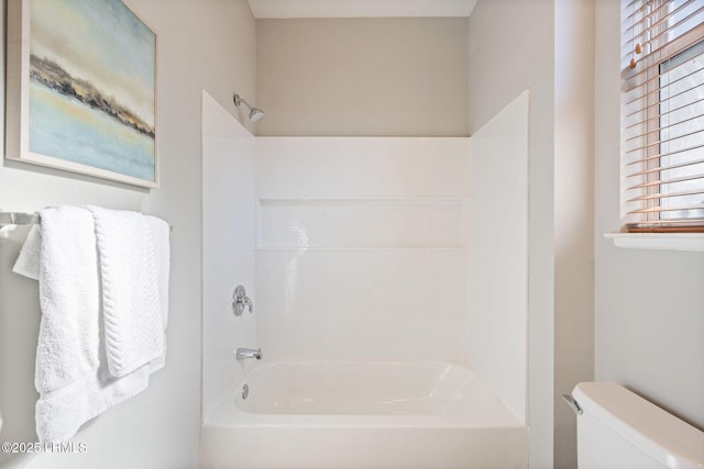 bathroom featuring shower / tub combination and toilet