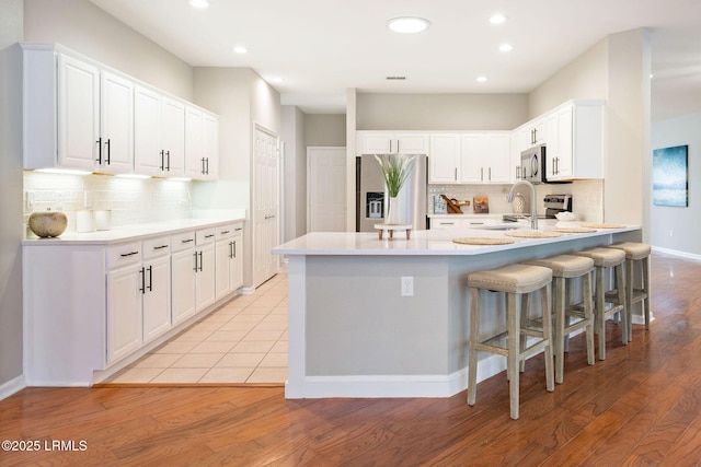 kitchen featuring white cabinetry, appliances with stainless steel finishes, sink, and a kitchen breakfast bar