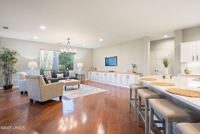 living room with a notable chandelier and dark hardwood / wood-style flooring