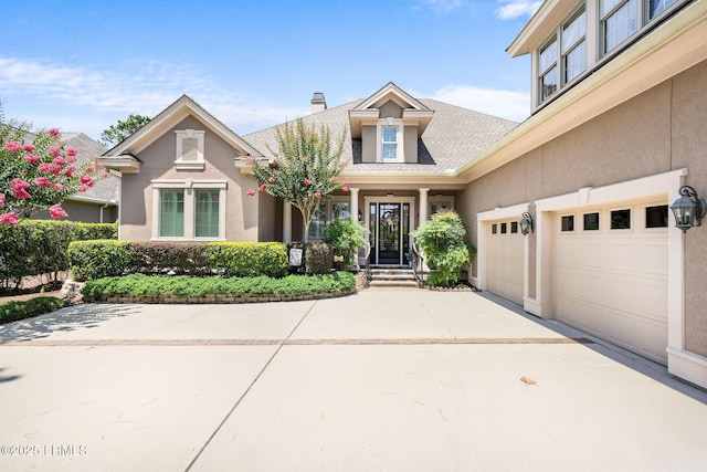10 Anchor Bay Ct, Bluffton, SC 29910 - view of front of house with driveway, a garage, roof with shingles, a chimney, and stucco siding