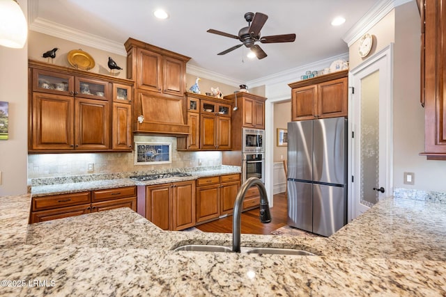10 Anchor Bay Ct, Bluffton, SC 29910 - kitchen featuring stainless steel appliances, brown cabinetry, wood finished floors, ceiling fan, and light stone counters
