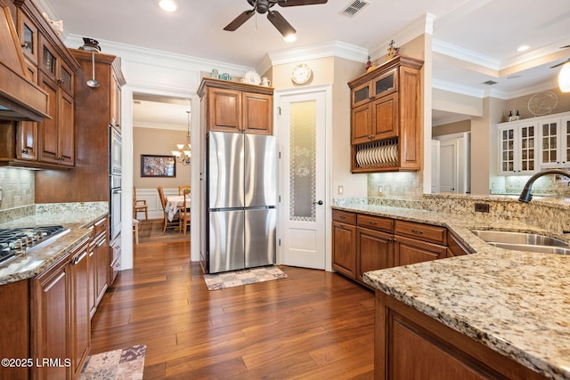 10 Anchor Bay Ct, Bluffton, SC 29910 - kitchen with appliances with stainless steel finishes, a ceiling fan, dark wood-style floors, brown cabinetry, and crown molding