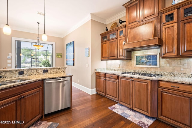 10 Anchor Bay Ct, Bluffton, SC 29910 - kitchen with appliances with stainless steel finishes, dark wood-style flooring, brown cabinetry, decorative backsplash, and ornamental molding
