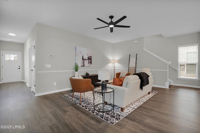 living room with dark hardwood / wood-style flooring and ceiling fan