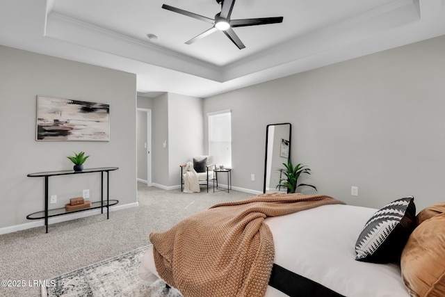 carpeted bedroom with a tray ceiling and ceiling fan