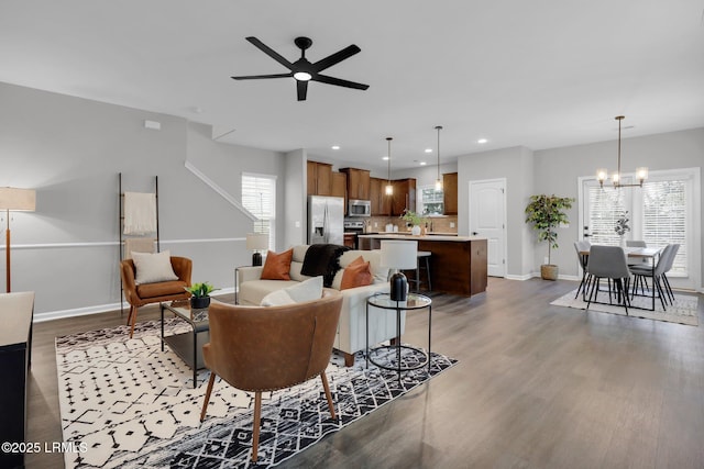 living room featuring hardwood / wood-style flooring and ceiling fan with notable chandelier