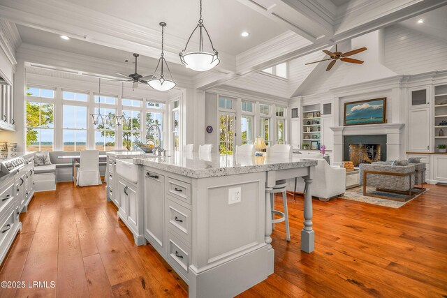 1448 Gleasons Landing Dr, Saint Helena Island, SC 29920 - kitchen with ceiling fan, light wood finished floors, a fireplace, a kitchen breakfast bar, and open floor plan
