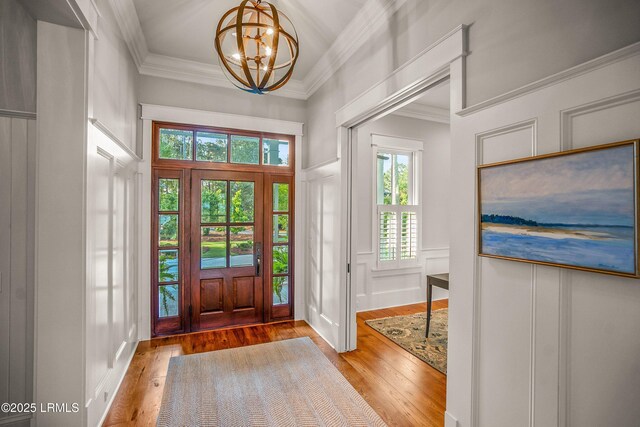 1448 Gleasons Landing Dr, Saint Helena Island, SC 29920 - entryway with crown molding, a chandelier, hardwood / wood-style floors, and a decorative wall