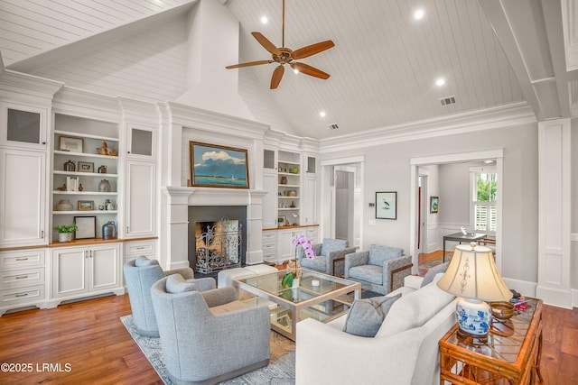 1448 Gleasons Landing Dr, Saint Helena Island, SC 29920 - living room with visible vents, built in features, ceiling fan, a large fireplace, and light wood finished floors