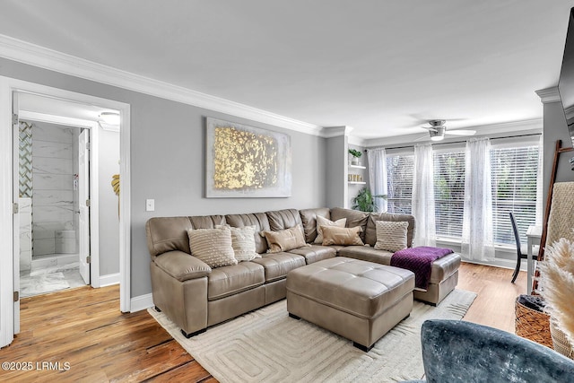 living area with baseboards, light wood finished floors, a ceiling fan, and crown molding