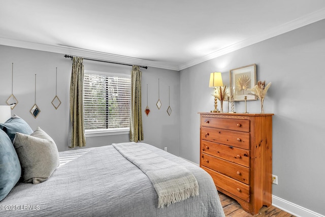 bedroom featuring crown molding, baseboards, and wood finished floors