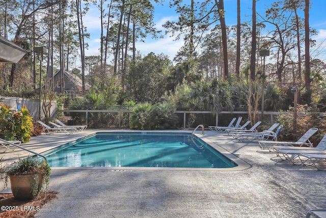 community pool featuring fence and a patio