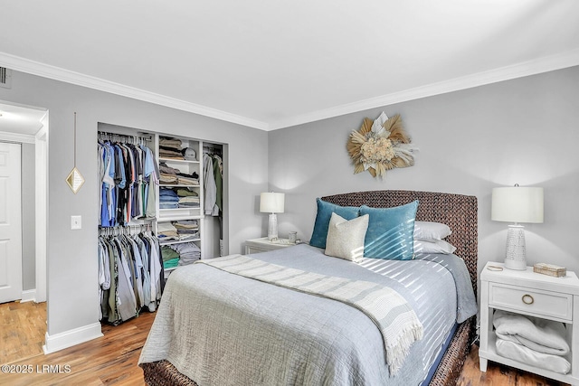 bedroom featuring crown molding, a closet, and wood finished floors