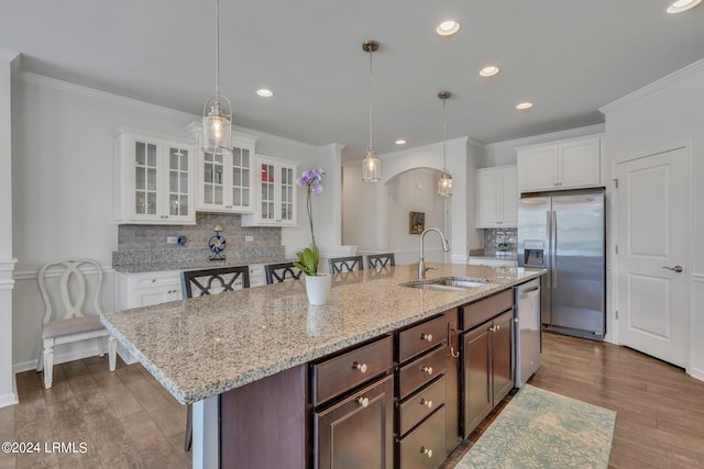 kitchen featuring dark brown cabinetry, sink, stainless steel appliances, and a kitchen bar