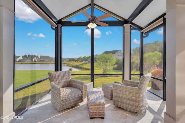 sunroom / solarium with a water view, lofted ceiling, and ceiling fan