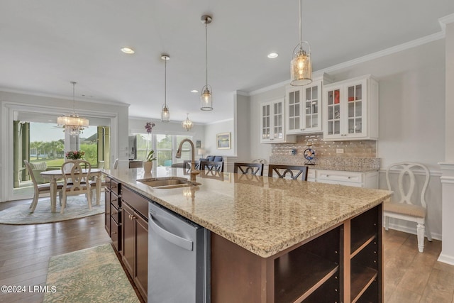 kitchen featuring pendant lighting, white cabinetry, dishwasher, sink, and an island with sink