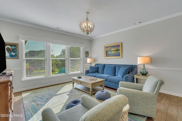 living room with crown molding, a chandelier, and hardwood / wood-style flooring