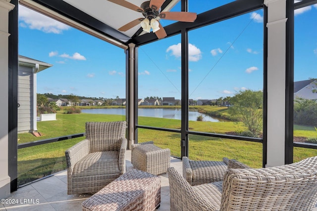 sunroom featuring a water view and ceiling fan