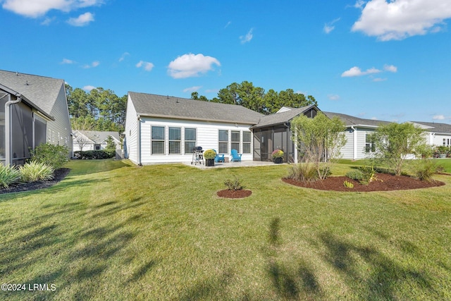 rear view of house featuring a sunroom, a lawn, and a patio area