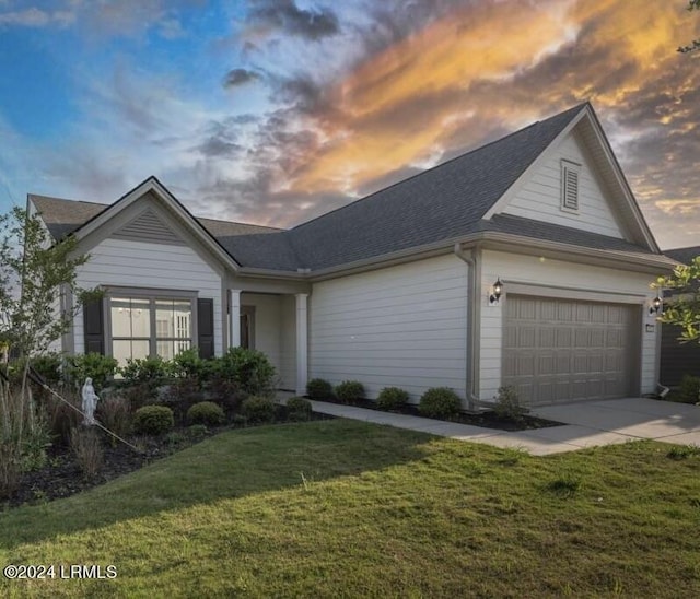 single story home featuring a garage and a lawn