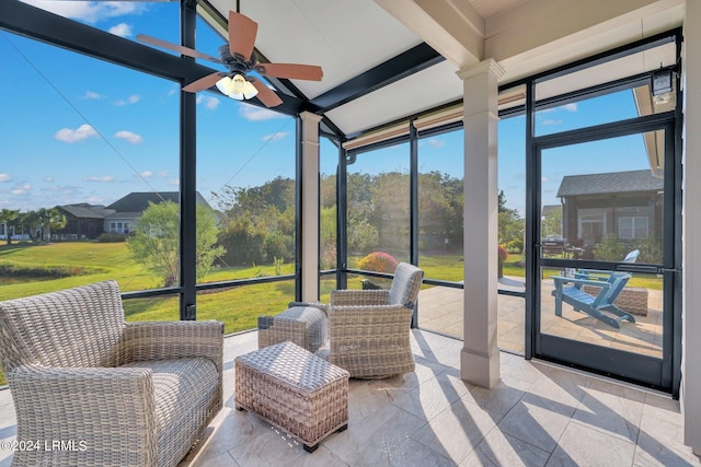 sunroom with ceiling fan, a healthy amount of sunlight, and beam ceiling