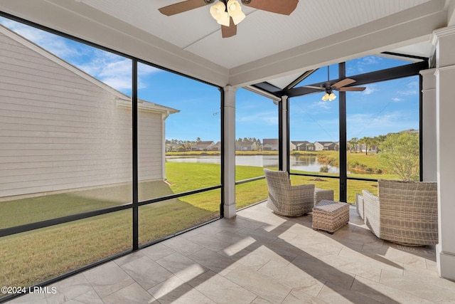 unfurnished sunroom featuring a water view and ceiling fan