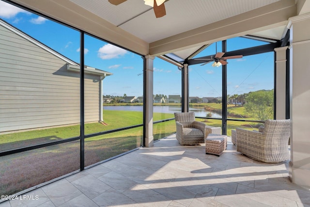 unfurnished sunroom with ceiling fan and a water view