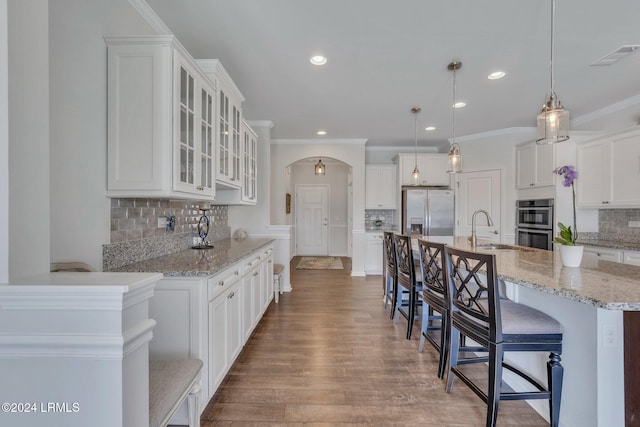 kitchen with white cabinetry, appliances with stainless steel finishes, pendant lighting, and a kitchen breakfast bar