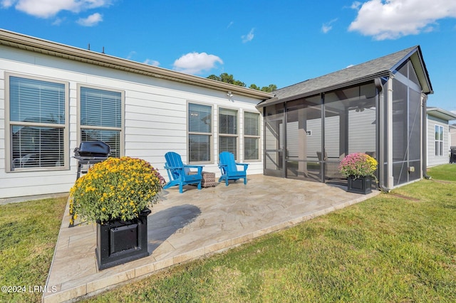 back of house featuring a patio, a yard, and a sunroom