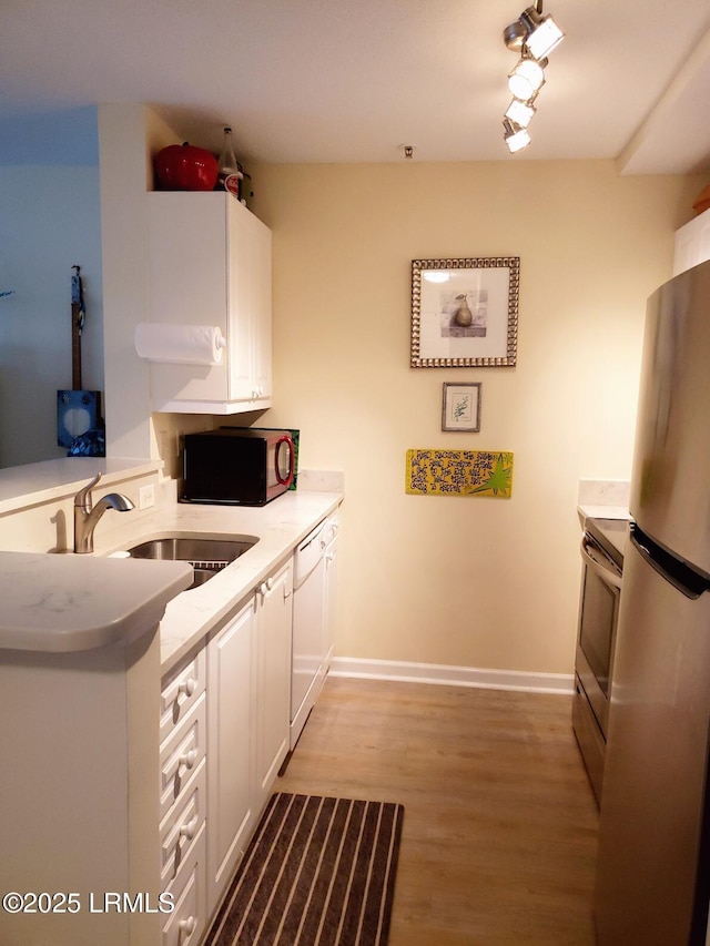 70 Helmsman Way Unit 1410, Hilton Head Island, SC 29928 - kitchen featuring stainless steel appliances, white cabinets, light wood-style flooring, and a peninsula
