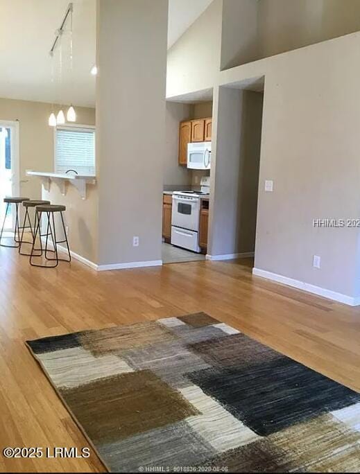 14 Arbormeade Cir, Bluffton, SC 29910 - kitchen featuring white appliances, track lighting, light wood finished floors, a breakfast bar area, and high vaulted ceiling