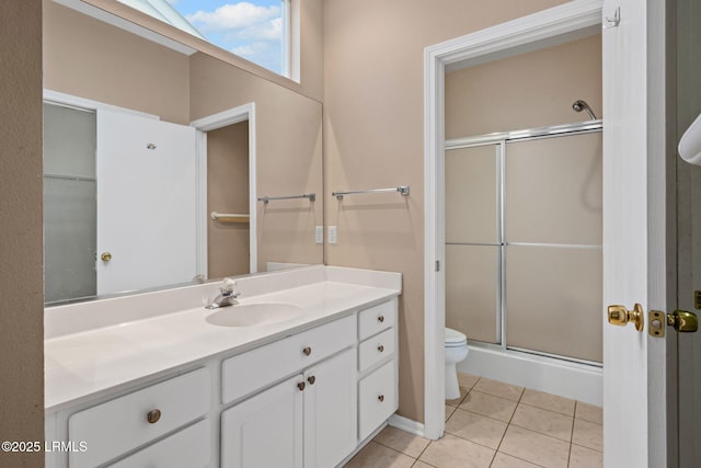 bathroom with tile patterned flooring, vanity, an enclosed shower, and toilet