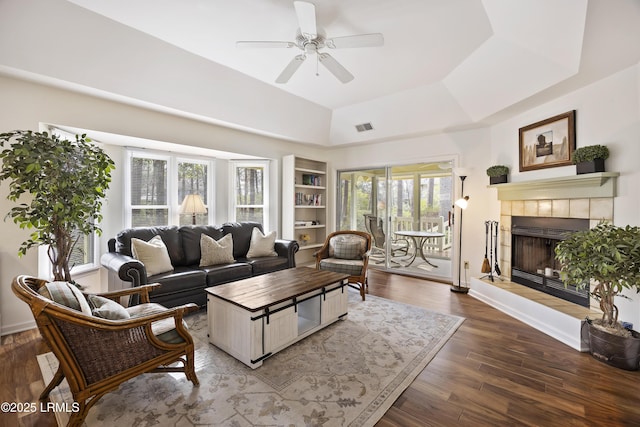 living room with hardwood / wood-style flooring, a fireplace, plenty of natural light, and a tray ceiling